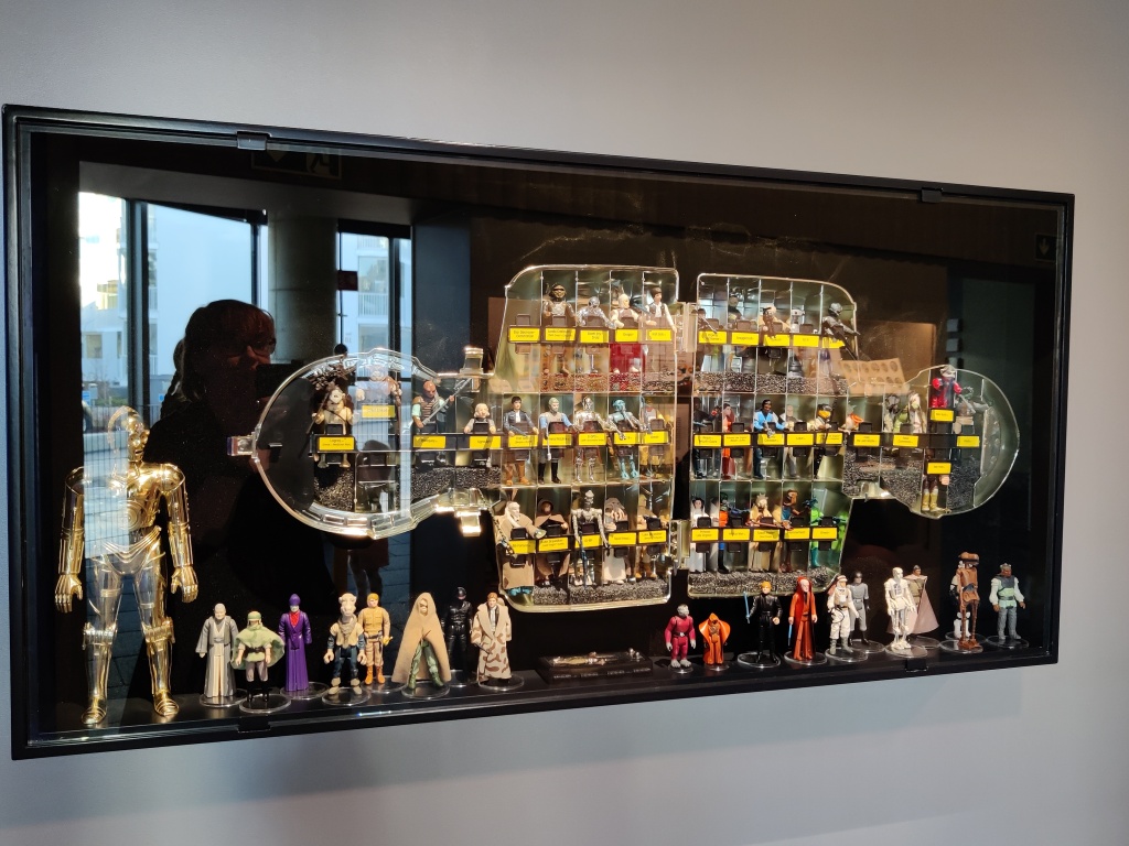 Kuva lasikaapista, jonka sisällä on valtava määrä erilaisia Star Wars -hahmoja. Lasin pinnasta heijastuu Katja ottamassa valokuvaa.